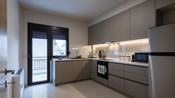 Een moderne keuken met een inbouwoven, een magnetron en een koelkast.