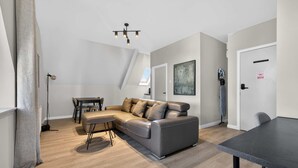 Una sala de estar moderna con un sofá modular, una mesa de comedor y una lámpara de techo.