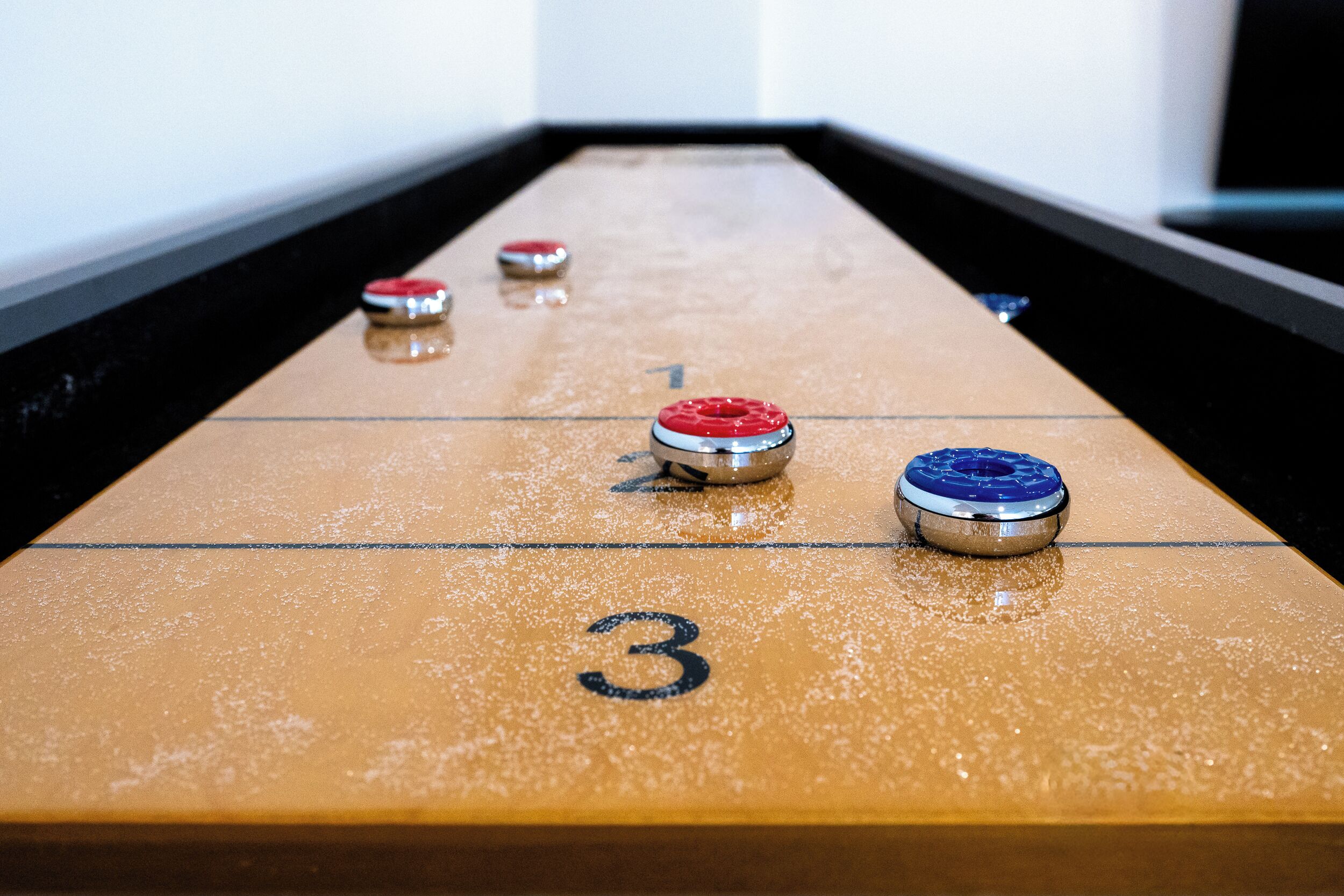 A shuffleboard table with numbered ends and pucks.