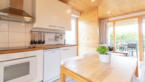Een moderne keuken met witte kastjes, een houten aanrecht en een vaatwasser.