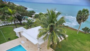 A pool, palm trees, and a view of the ocean. - Romantic, Oceanfront Getaway! (Sosúa)