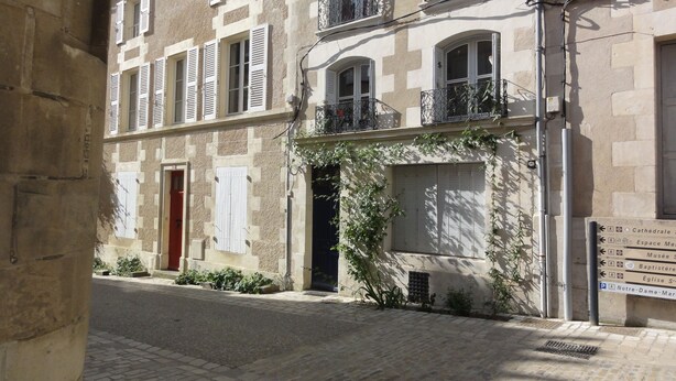 A narrow street with buildings featuring stone facades, shutters, and balconies. - Poitiers Centre Cathédrale Studio 20 m² (215 sq. ft.) (Poitiers)