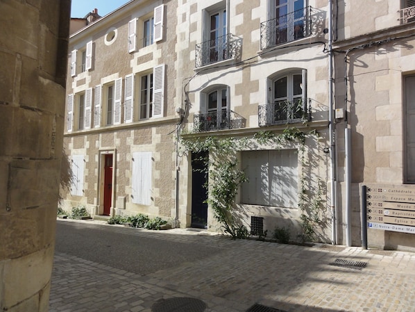 A narrow street with buildings featuring stone facades, shutters, and balconies. - Poitiers Centre Cathédrale Studio 20 m² (215 sq. ft.) (Poitiers)