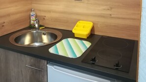 A kitchen with a sink, a small countertop, a microwave, and a refrigerator. - Poitiers Centre Cathédrale Studio 20 m² (215 sq. ft.) (Poitiers)