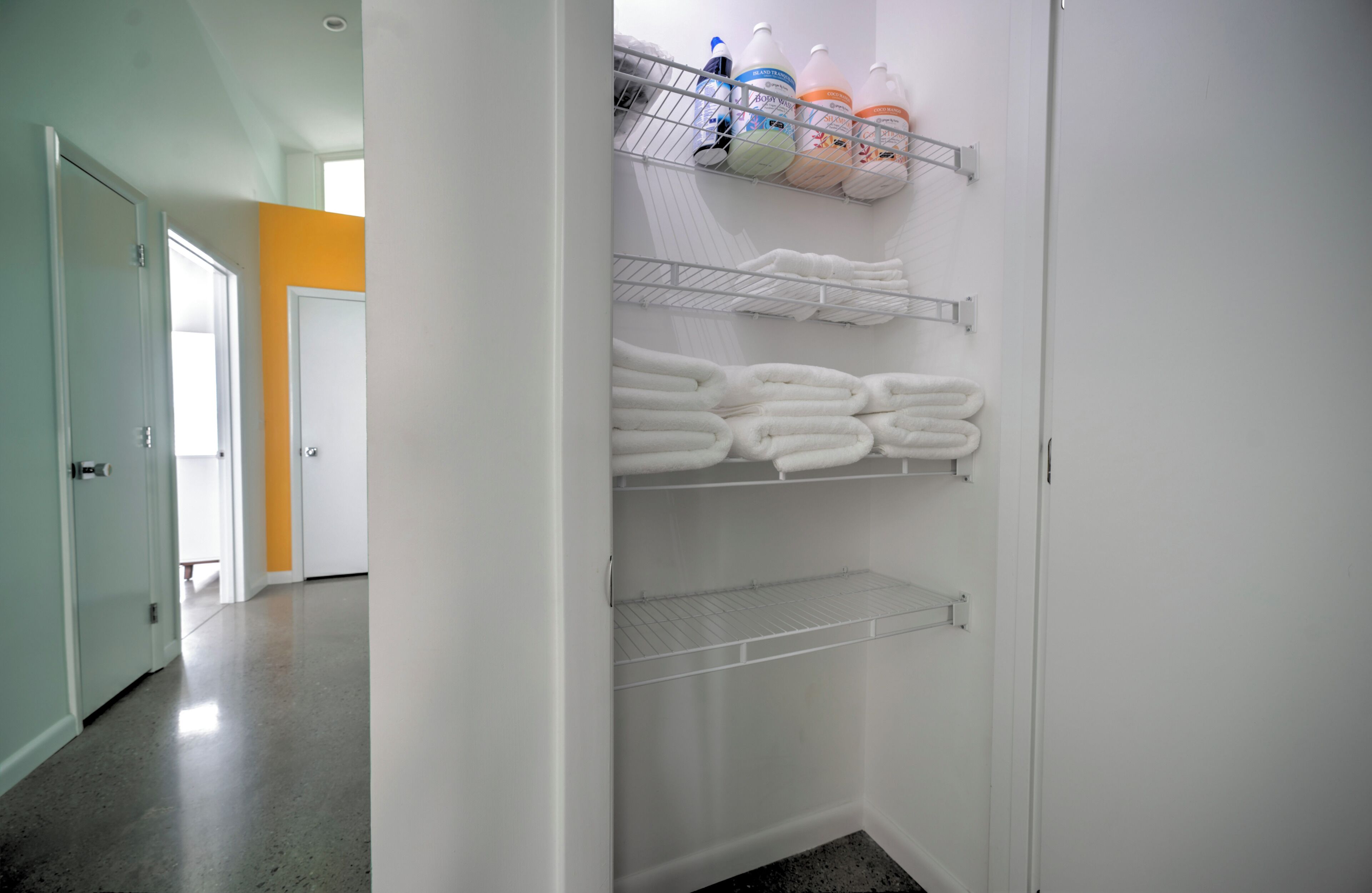 Um closet amplo com prateleiras para toalhas dobradas e caixas organizadoras.