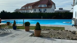 Ein Wohngebiet mit Schwimmbad, Topfpflanzen und einer Terrassenanlage.