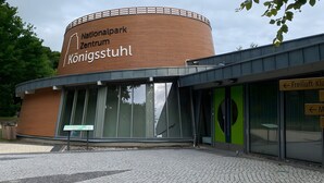 Ein Gebäude mit einem Schild, auf dem 'Nationalpark Zentrum Königsstuhl' steht.
