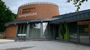 A building with a sign reading 'Nationalpark Zentrum Königsstuhl.' - Apartment for 3 Guests, 43 m², Private Terrace, Garden, and Wi-Fi (Sagard)