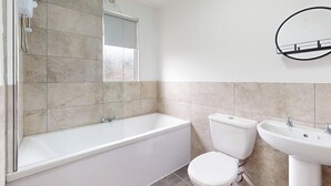 A bathroom with a bathtub, toilet, and sink. - House Sleeps 10 With Wifi (Sunderland)
