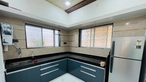 A kitchen with a refrigerator, double sink, and windows. - Sanvi farmhouse. Hill view with waterfalls. (Thoran)