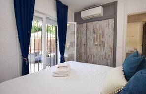 Ein Schlafzimmer mit Bett, Kleiderschrank und Klimaanlage.