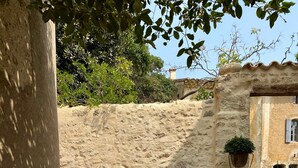 A sunlit outdoor seating area with stone steps, cushions, and a planter. - Holiday Home 'Présbytère' with Shared Pool, Shared Garden and Wi-Fi (Lieuran-lès-Béziers)