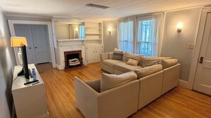 A modern living room with a sectional sofa, a fireplace, and a dining area with a table and chairs. - Spacious Home with fenced in yard, close to everything, great for families (Rutherfordton)