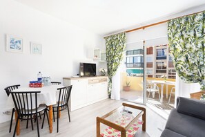 Eine moderne Küche mit Essbereich, einer Couch und Blick ins Freie.