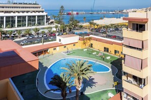 Ein Hotel mit Pool, Meerblick und Parkplatz.