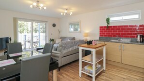 Un espace de vie compact comprenant un coin repas, une kitchenette et un canapé.