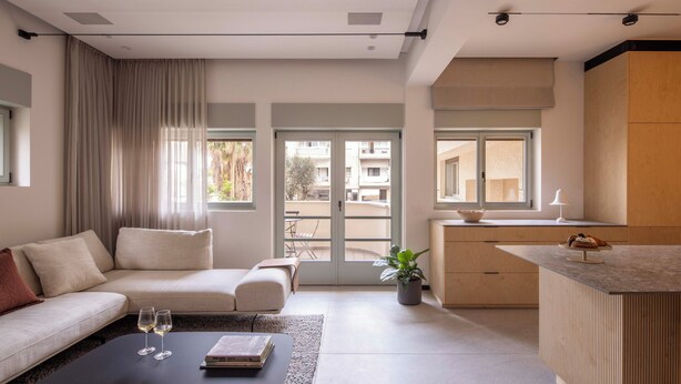 A modern living room with a sofa, coffee table, and a view of the outside. - Hayarkon 70 - Boutique Aparthotel (Tel Aviv)