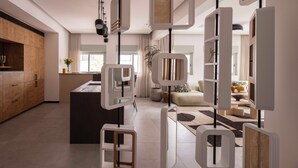 A modern kitchen with a central island, a dining area with a sofa and table, and a living room with a large window. - Hayarkon 70 - Boutique Aparthotel (Tel Aviv)