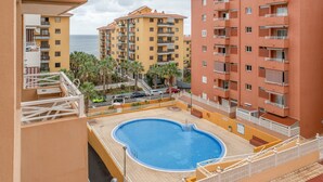 A residential building with a swimming pool, balconies, and a view of the sea. - Vacation Apartment 'Vivienda Carolina' with Mountain View, Shared Pool and Wi-Fi (Santa Cruz de Tenerife)