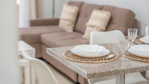 A dining table set with plates, cutlery, and glasses, with a woven placemat. - Vacation Apartment 'Vivienda Carolina' with Mountain View, Shared Pool and Wi-Fi (Santa Cruz de Tenerife)