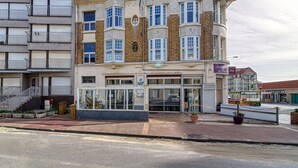 A multi-story hotel with a corner entrance, large windows, and a balcony on the second floor. - L’Attitude Mer - À 20 m de la plage (Bray-Dunes)