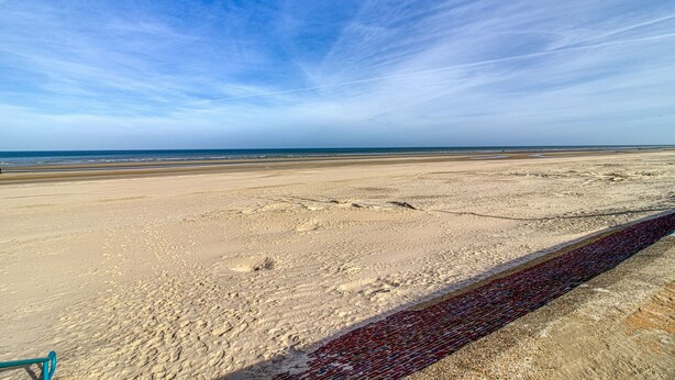 A beach with a clear sky, sandy shore, and a red brick path. - L’Attitude Mer - À 20 m de la plage (Bray-Dunes)