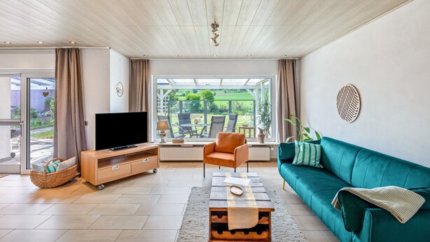 Una sala de estar moderna con televisor, sofá y mesa de centro.