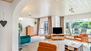 Una sala de estar amplia con televisor, sofá y mesa de centro.