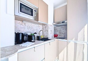 A compact kitchen with a microwave, toaster, sink, and cabinets. - N&J - STUDIO ANNA - Central Nice • AC • Walk to beach (Nice)