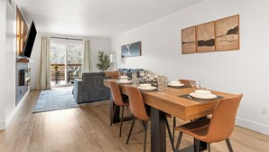 A dining area with a wooden table, chairs, and a view of a balcony.