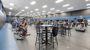 A gym with exercise equipment, seating areas, and a blue-striped wall.
