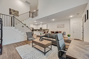 A spacious living area with a staircase, a kitchen, and a dining area. - FS832 | Frisco Retreat | 2BD | Universal Kids Resort (Frisco)