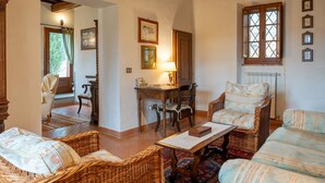 A cozy living room with wicker furniture, a wooden coffee table, and a dining table with chairs.