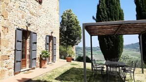 A stone building with a covered patio and outdoor seating.