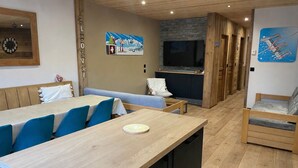 A modern interior with a dining area, a kitchen, and a seating area. - Comfortable 15-person apartment near the ski slopes. Parking lots (Saint-Sorlin-d'Arves)