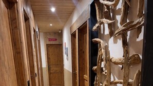 A hallway with wooden doors and a wall-mounted wooden sculpture. - Comfortable 15-person apartment near the ski slopes. Parking lots (Saint-Sorlin-d'Arves)
