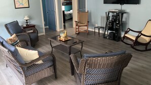 A living room with wicker furniture, a flat-screen TV, and a small table with a decorative item. - Spend time with family & friends. Fish, swim, kayak, or relax on private dock! (Lexington)