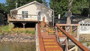 A wooden dock leading to a house with a porch. - Spend time with family & friends. Fish, swim, kayak, or relax on private dock! (Lexington)