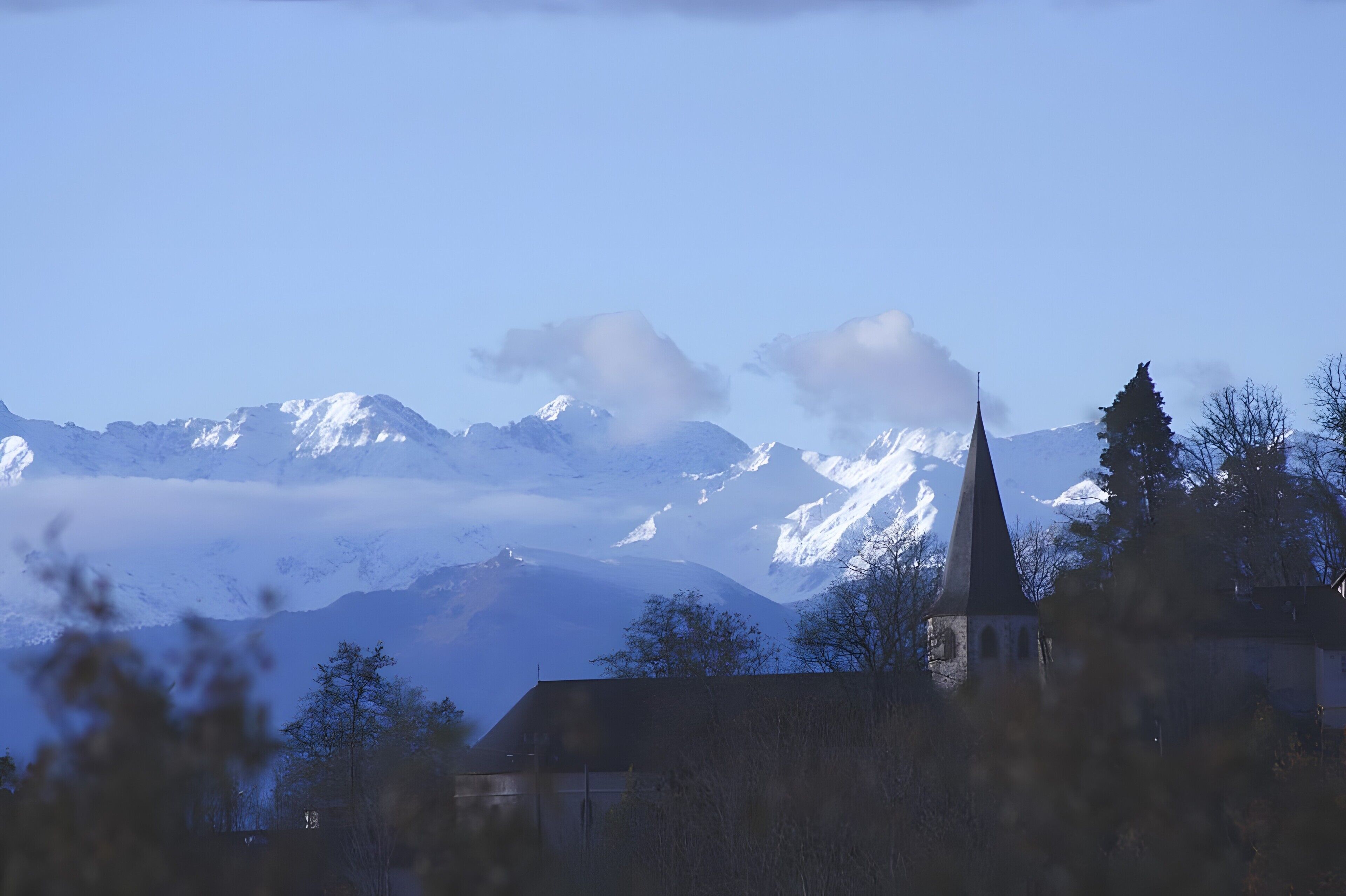Berglandschap met een kerk en besneeuwde toppen.