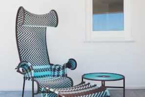 A chair with a chevron pattern and a small round table. - Riva Estate Villa by LeDhome (Trappeto)