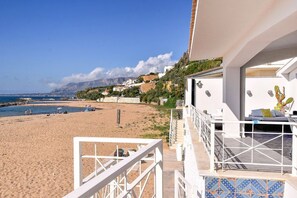 A beach view with a balcony overlooking the sea, a white building with a tiled floor, and a mountainous backdrop. - Riva Estate Villa by LeDhome (Trappeto)