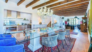 A spacious kitchen with a central island, wooden beams, and a chandelier. - Modern design Mallorca estate among nature (Búger)