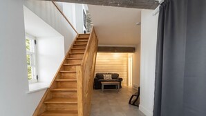 Una escalera que lleva a una sala de estar con un sofá y una mesa de centro.