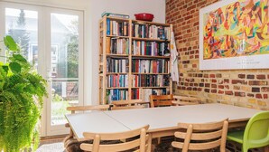 A dining area with a brick wall, a bookshelf, and a painting. - 3 Person Holiday Home in Aarhus C (Aarhus)