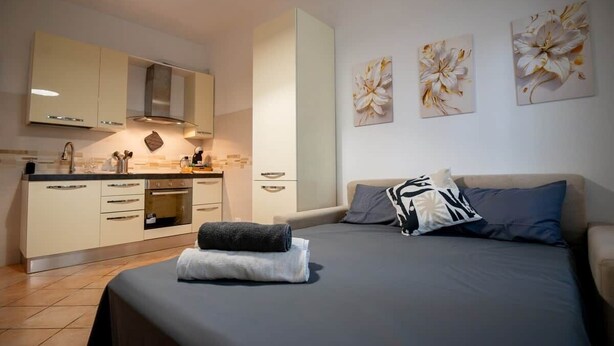 Une chambre à coucher avec un lit, des oreillers, une table de chevet et une commode.
