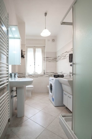 Ein modernes Badezimmer mit Waschbecken, Toilette und Waschmaschine.