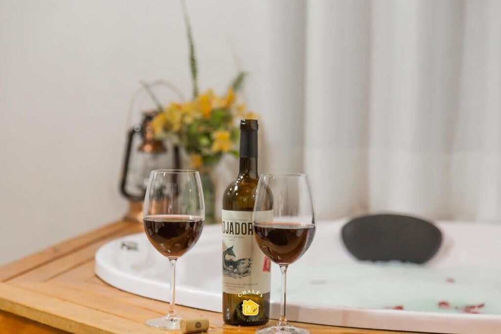 A bottle of wine and two glasses on a tray.