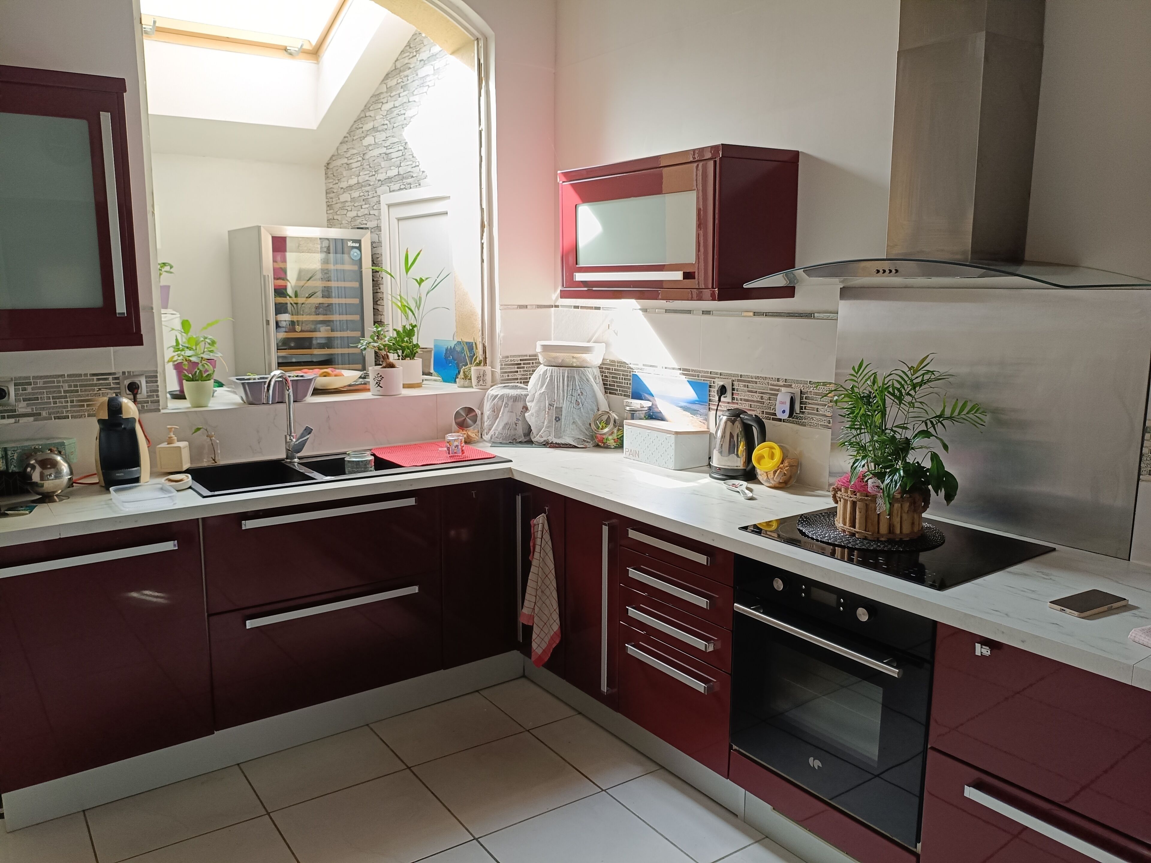 Een moderne keuken met een ingebouwde oven, een magnetron en een rvs afzuigkap.