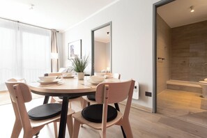 A modern dining area with a round table, chairs, and a potted plant. - Departamento 4 Pax Barrio Italia (Santiago)