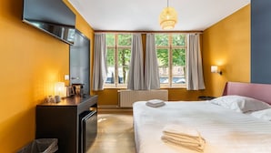 A hotel room with a bed, bedside table, desk, and a TV. - Amazing scenic city view room The Lake Suites (Brugge)